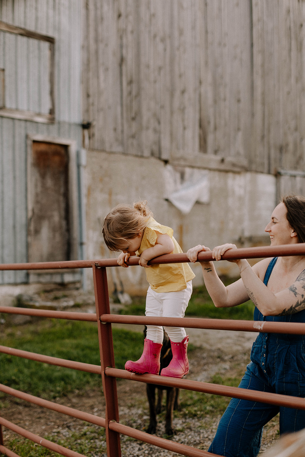 Samantha Turner helping her daughter climb a farm gate